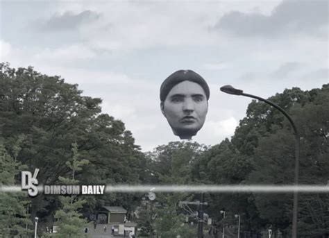 metal cover of giant floating head above house|giant floating head in sky.